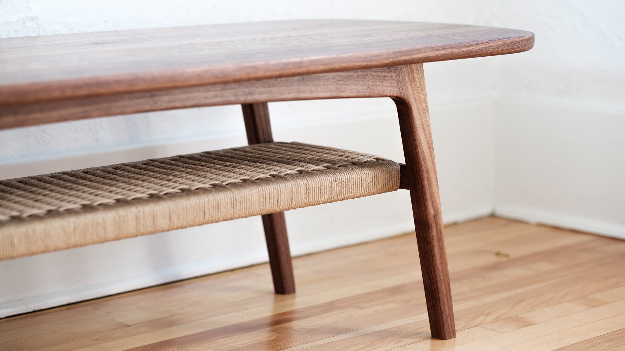 Mid century walnut coffee table, danish cord lower shelf, splayed legs, close up