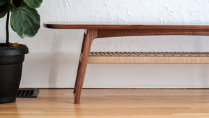 Mid century walnut coffee table, danish cord lower shelf, splayed legs, side view