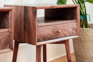 close up mid mentury walnut nightstand with one drawer, one open shelf, bevelled front edge, curly grain